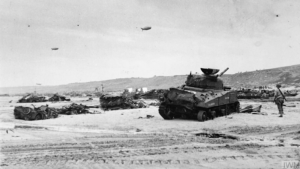 Un char M4 Sherman abandonné sur la plage d'Omaha, après les combats. Photo : IWM